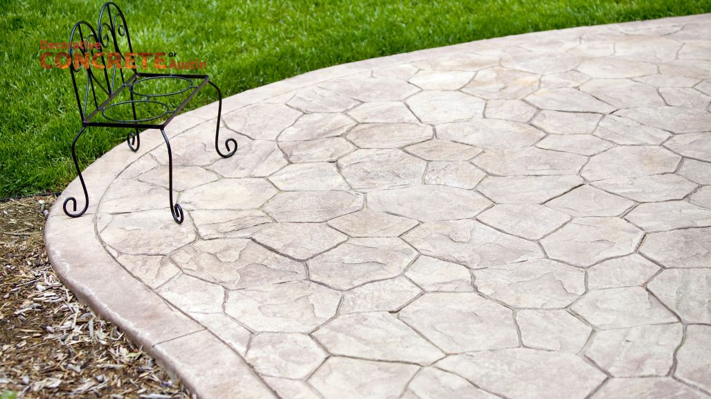 Stamped concrete patio with a hexagonal pattern, bordered by green grass.